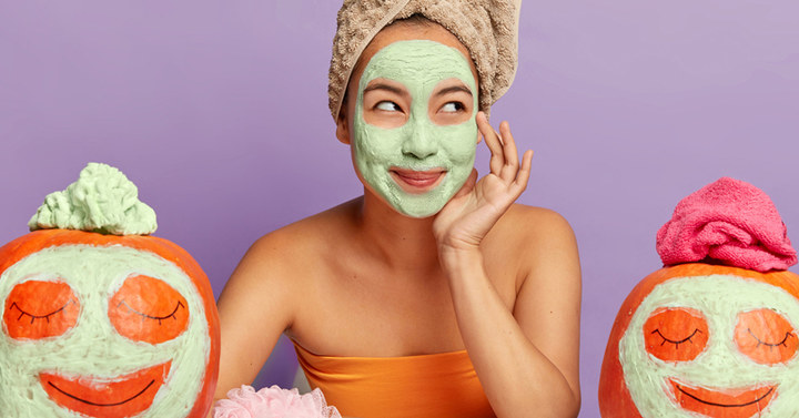 Frau mit Gesichtsmaske und Kürbisse