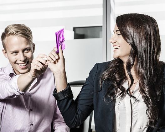 A young woman and a young man are laughing together.