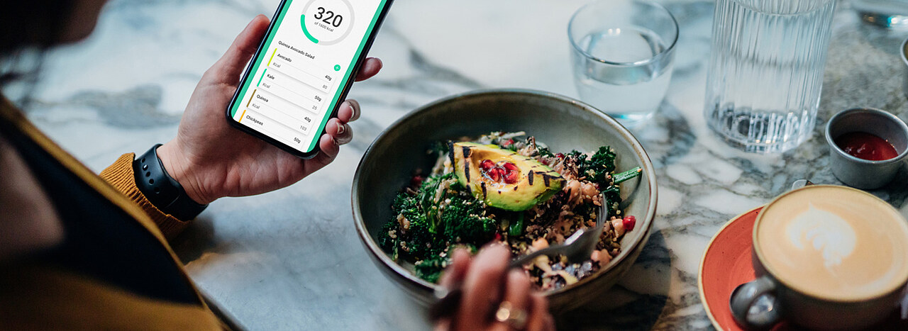 Satiety management gap Person eating a healthy meal and looking at their smartphone