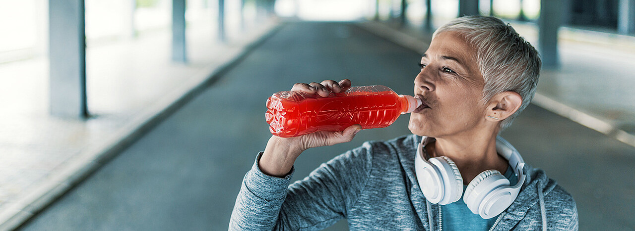 Consumer interest Woman drinking an isotonic drink whike exercising