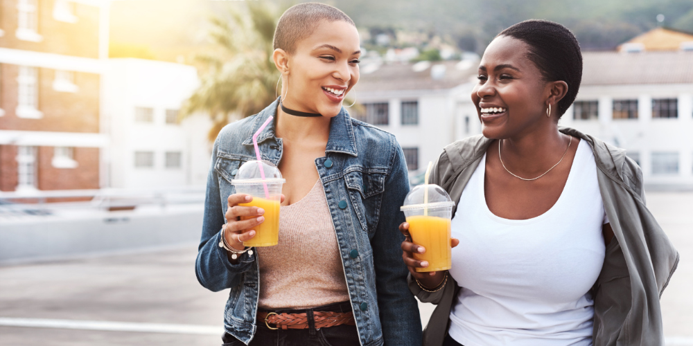 Two women drinking citrus beverages