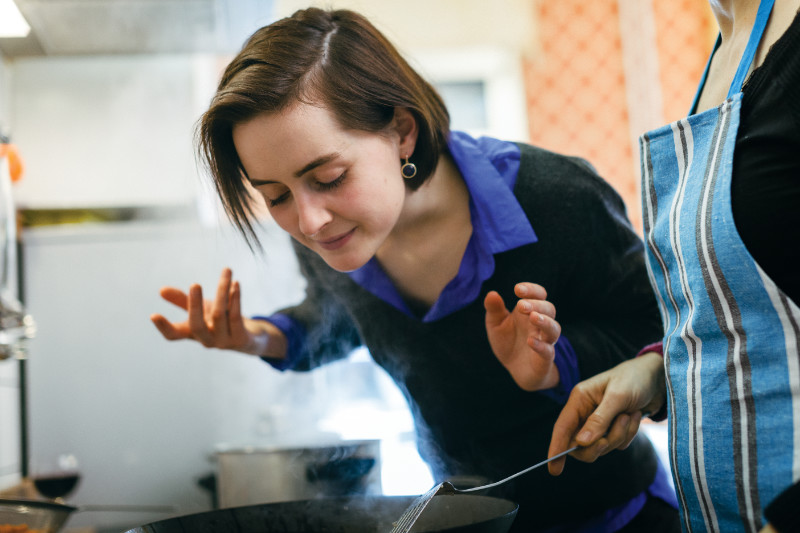 Woman smelling cooking food