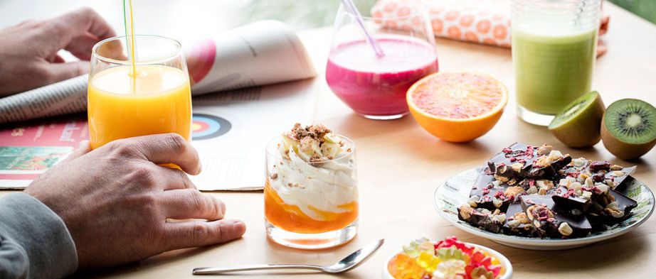 Several drinks, fruits and snacks on a table.