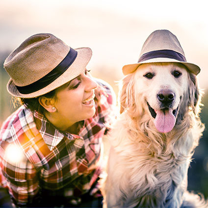 Eine Frau und ihr Hund tragen den gleichen Hut.