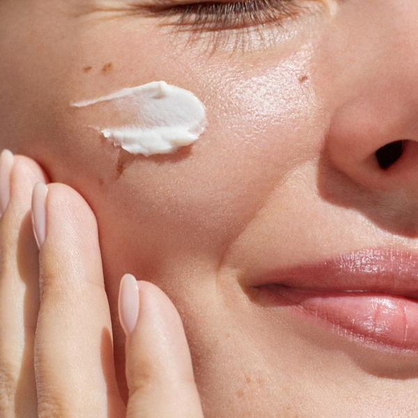Woman with sunscreen on her cheek