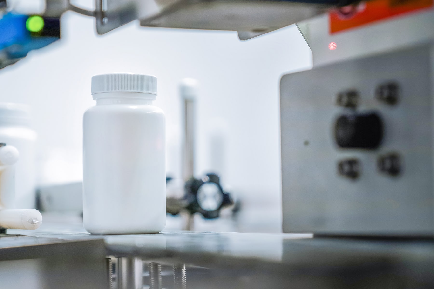 White plastic bottle positioned on a conveyor within a sterile production line for manufacturing probiotic products