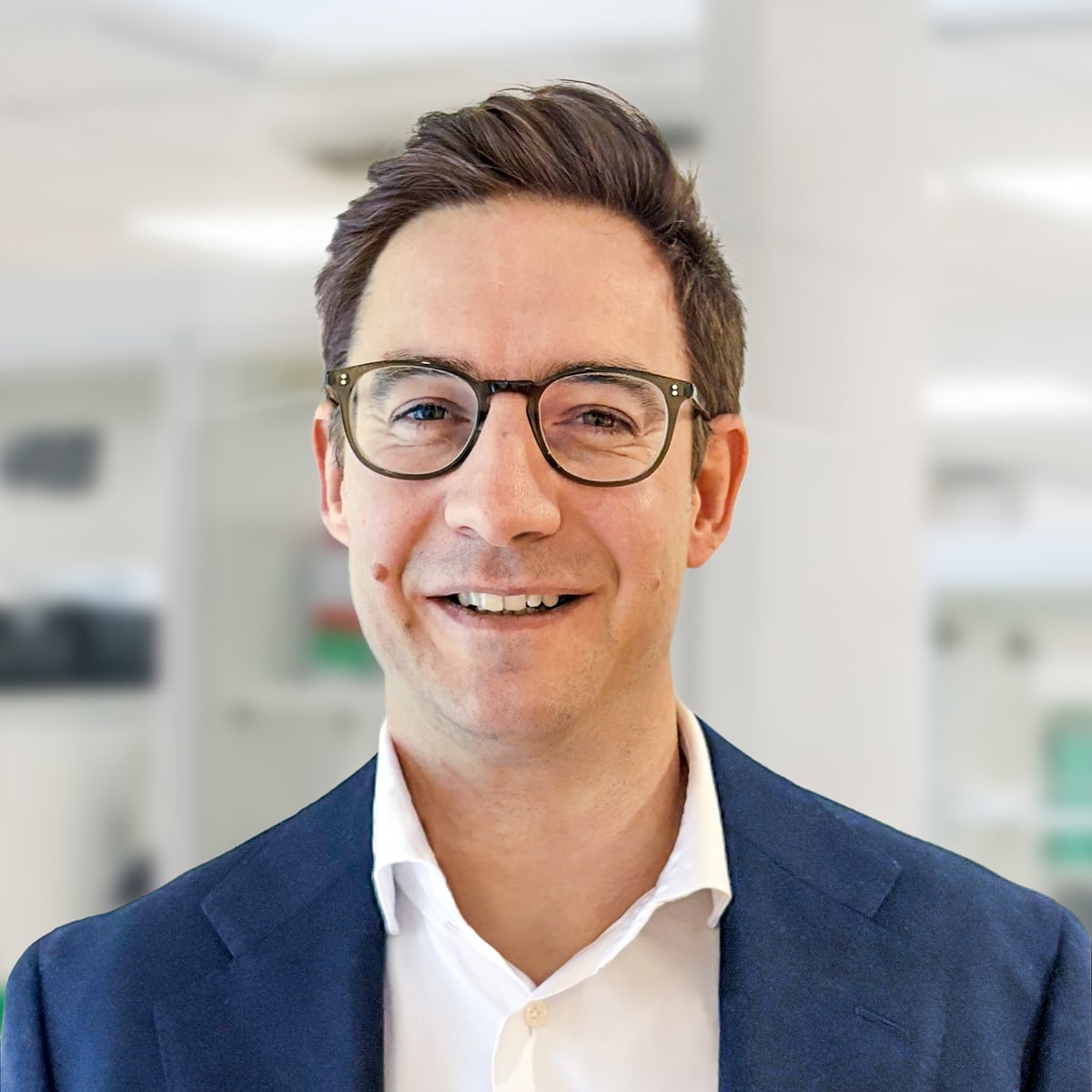 Porträt eines Fachmanns in Businesskleidung vor Laborhintergrund, aufgenommen für Kommunikation zu probiotischen Themen