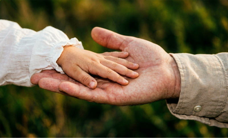 Child and adult holding hands