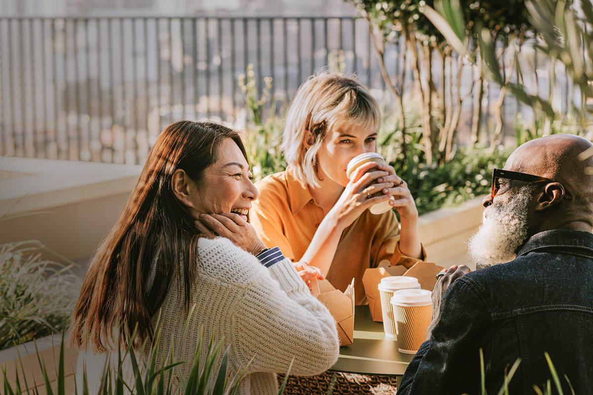 Two women and a man having coffee